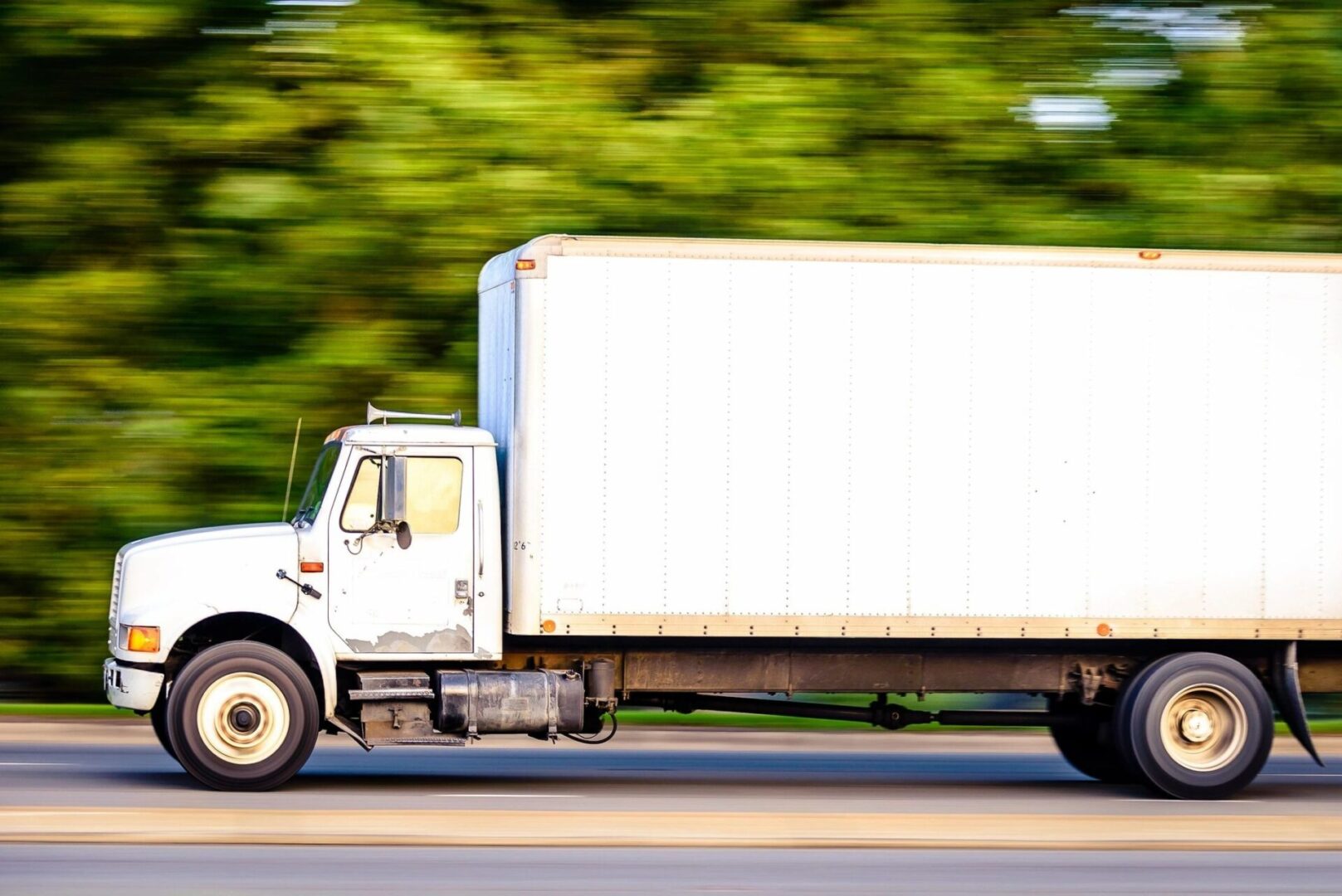 A white truck is driving down the street