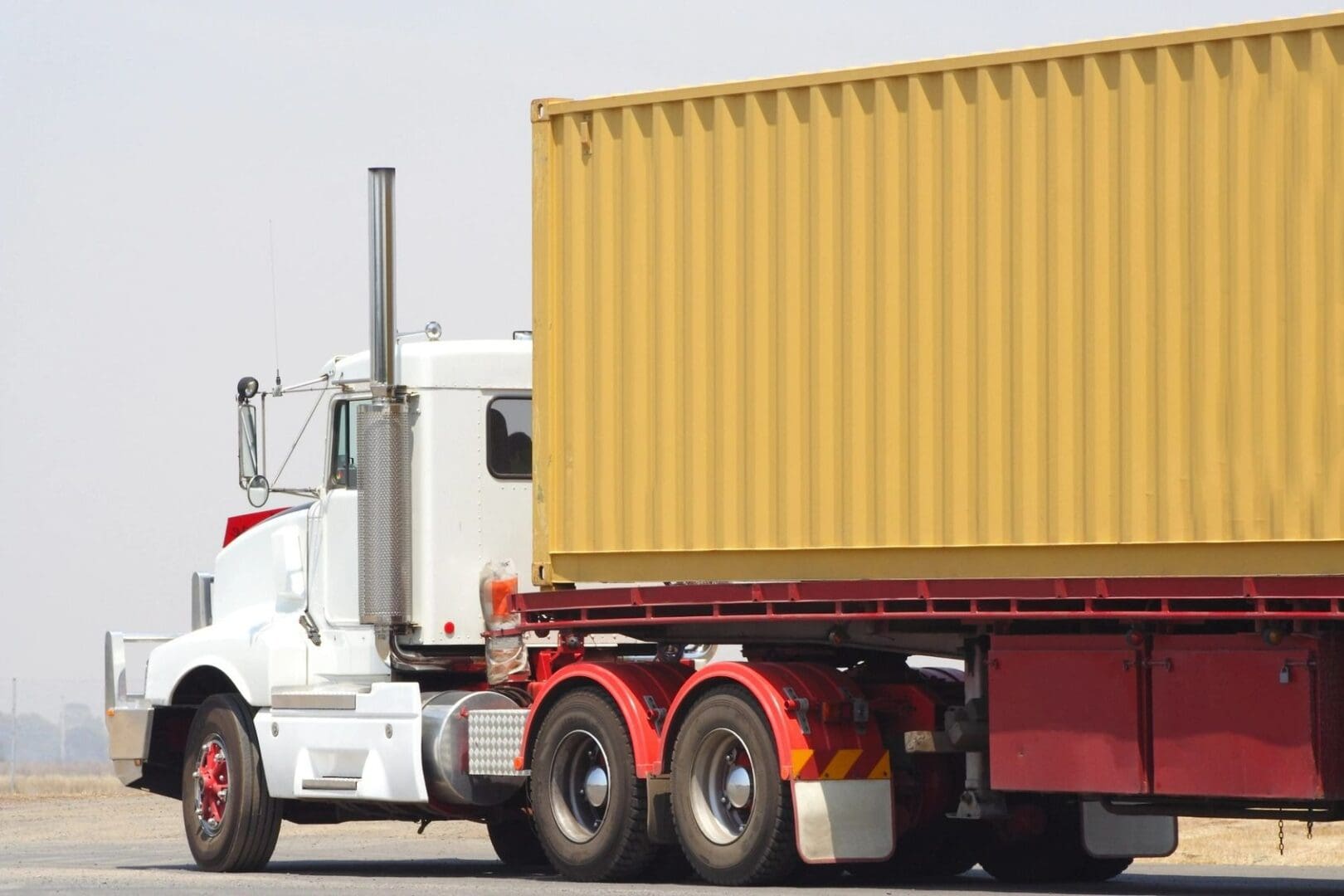 A large truck with a yellow container on the back.